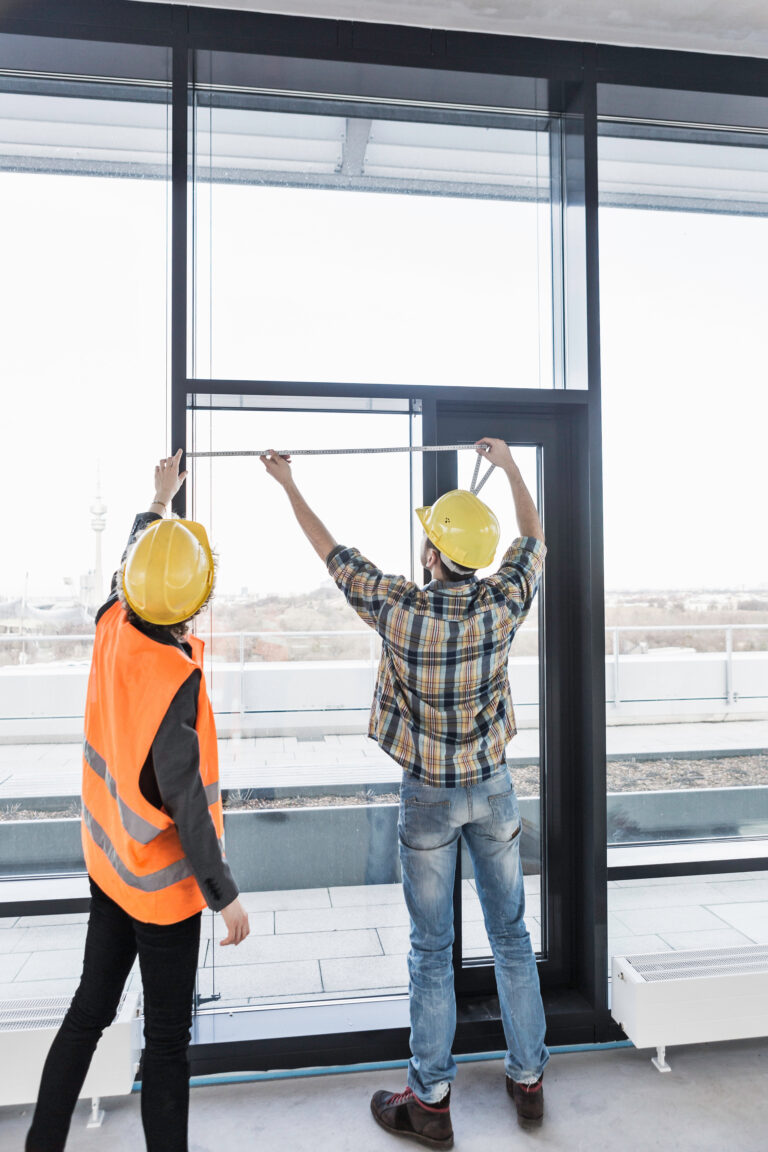 Builders measuring window and door installation