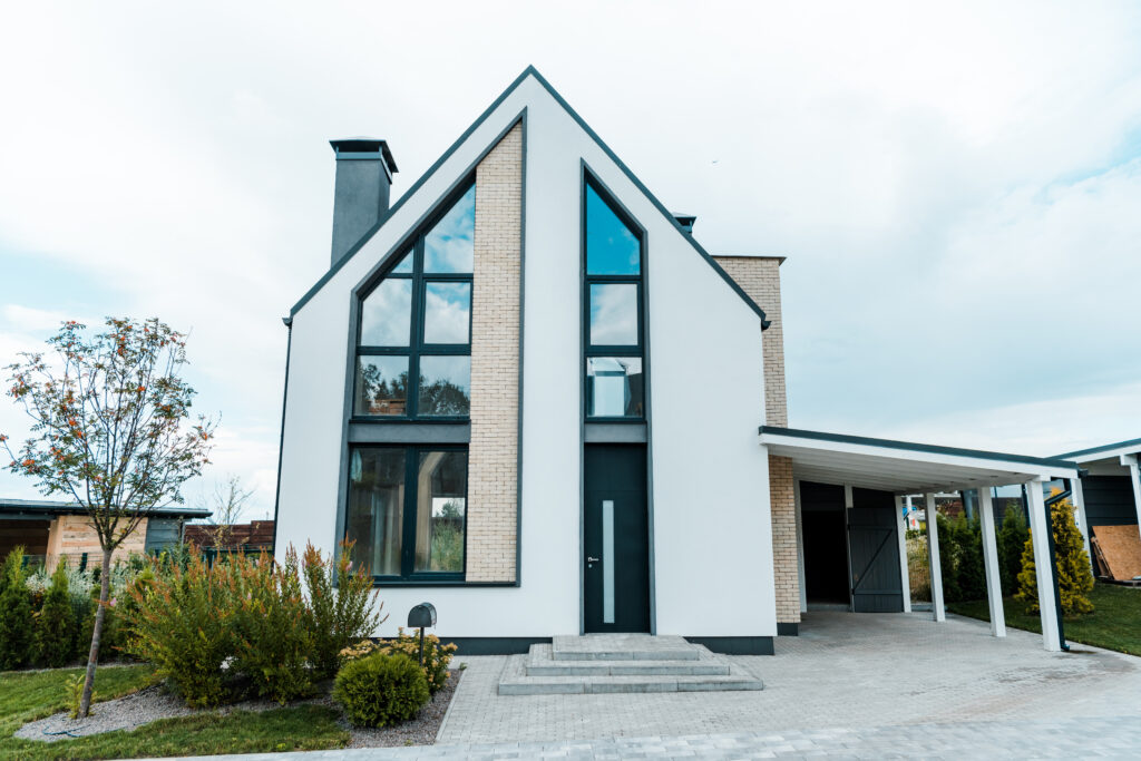 new luxury house near green trees and bushes on grass